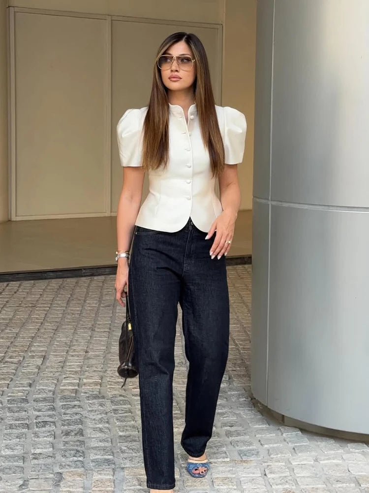 Woman in a white blouse and dark pants standing outdoors. Shirt puff sleeve trending most popular and elegant classy high quality top