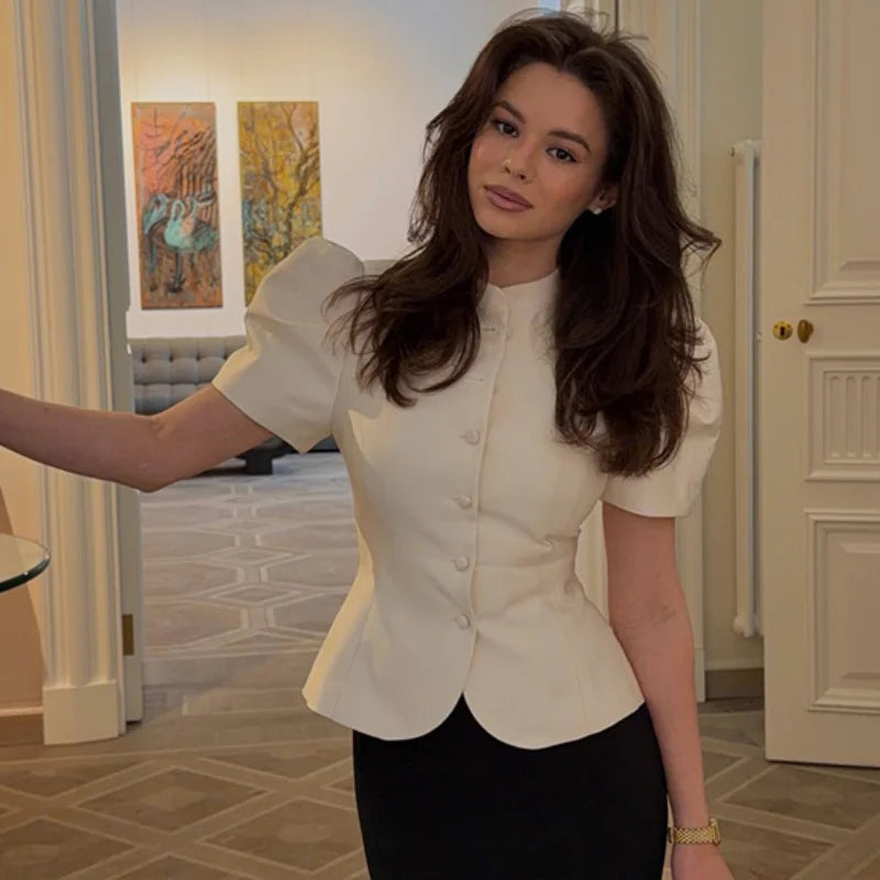 Woman wearing a white blouse in an indoor setting. Most popular and trending high quality button , elegant top.